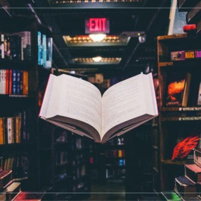 an open book floating in the air in the middle of a bookstore